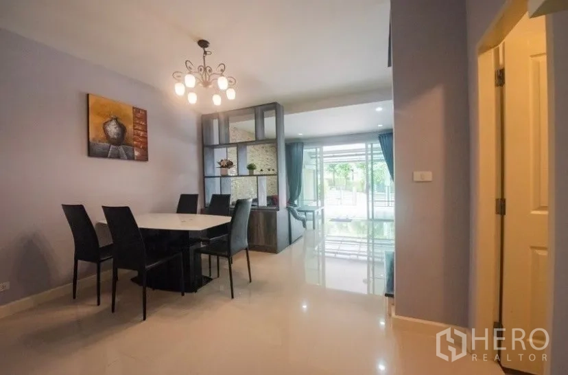 ทาวน์เฮาส์ ให้เช่าในSuan Luang, Bangkok - มุมรับประทานอาหารพร้อมโคมไฟแชนเดอเลียร์ โต๊ะทานข้าว และชั้นกั้นห้องติดประตูกระจกบานเลื่อน