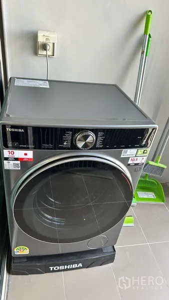 Condominium for rent - Laundry corner with a front-load washing machine on a tiled balcony.