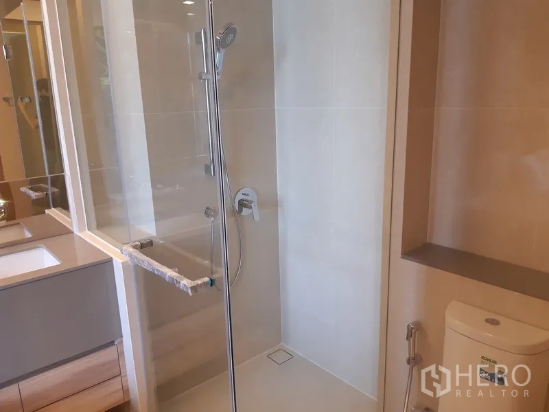 คอนโด ให้เช่าหรือขายในWatthana, Bangkok - ห้องน้ำโทนอบอุ่น พร้อมตู้กระจกอาบน้ำ อ่างล้างหน้า และโถสุขภัณฑ์