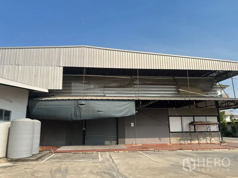 Warehouse for rent in Saphan Sung, Bangkok - Warehouse exterior with metal cladding, roller shutter loading bay and canopy.