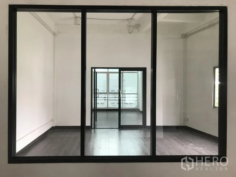 อาคารพาณิชย์ ให้เช่าในWatthana, Bangkok - มองผ่านหน้าต่างวงกบสีดำ เห็นสองห้องเชื่อมต่อรับแสงธรรมชาติ