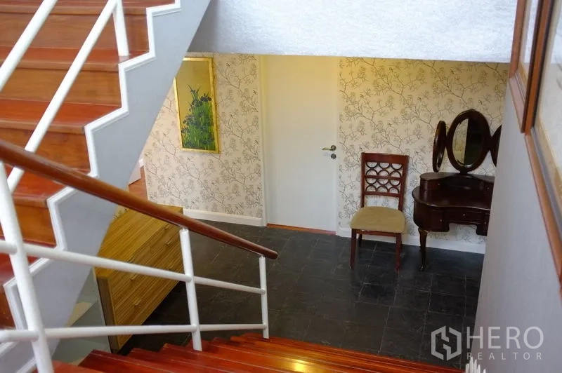 公寓 出租在Watthana, Bangkok - 楼梯间配抛光木阶、白色扶手和复古梳妆台。