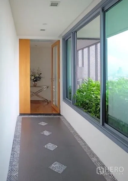 Condominium for rent or sale in Yan Nawa, Bangkok - Semi-outdoor corridor with large windows and planter balcony.
