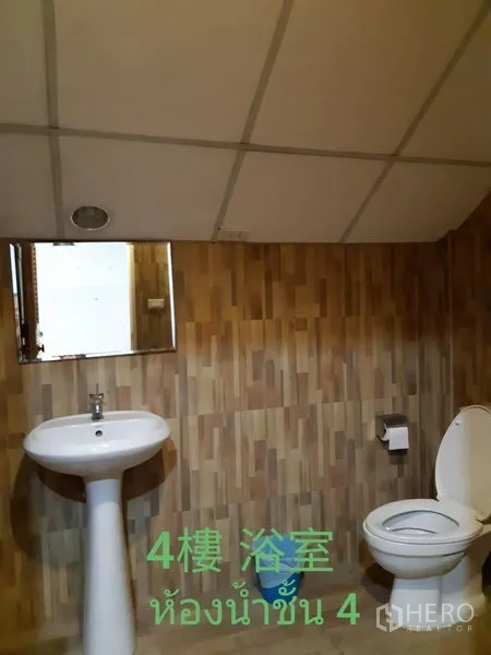 Townhouse for rent in Watthana, Bangkok - Bathroom with wood‑effect tiles, pedestal sink and toilet.