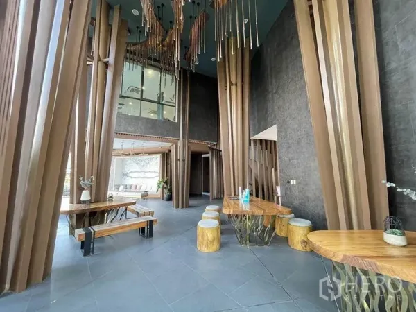 独立式住宅 出售在Pak Kret, Nonthaburi - 会所大堂，挑高空间与雕塑感木柱的现代设计。