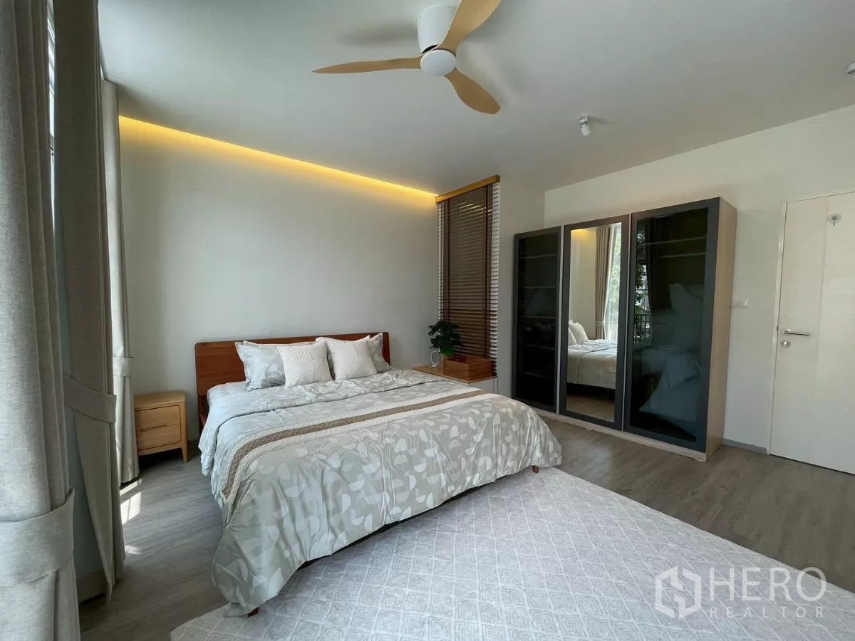联排别墅 出租在Prawet, Bangkok - 主卧配特大床、吊扇和镜面衣柜。