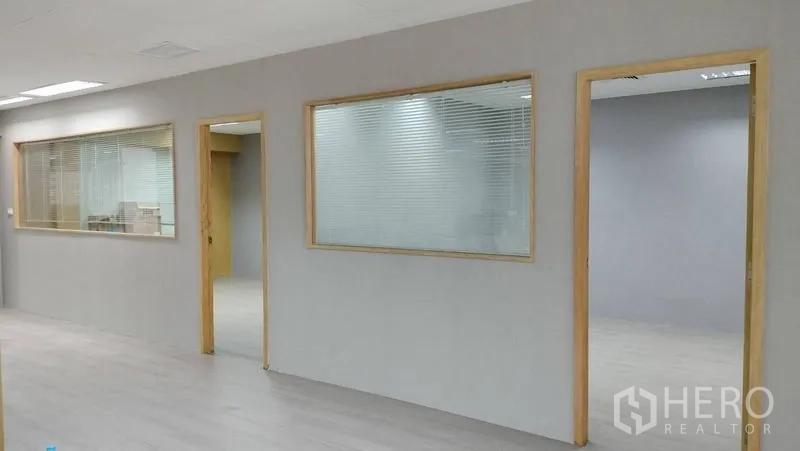 Office Space for rent or sale in Pathum Wan, Bangkok - Interior corridor with glass partitions and wooden frames leading to rooms.