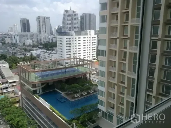 Condominium for rent in Sathon, Bangkok - Condominium facilities deck with rooftop tennis court over a large swimming pool and Bangkok skyline.