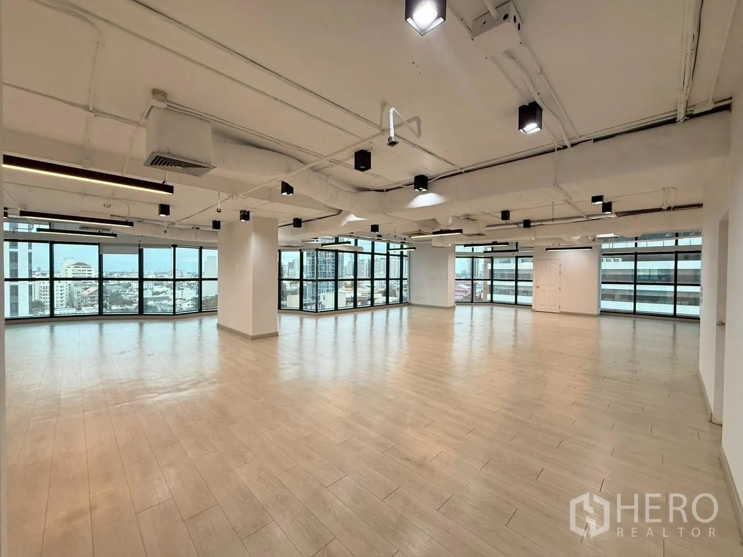 Office Space for rent in Watthana, Bangkok - Open-plan office with extensive windows on two sides and skyline views.