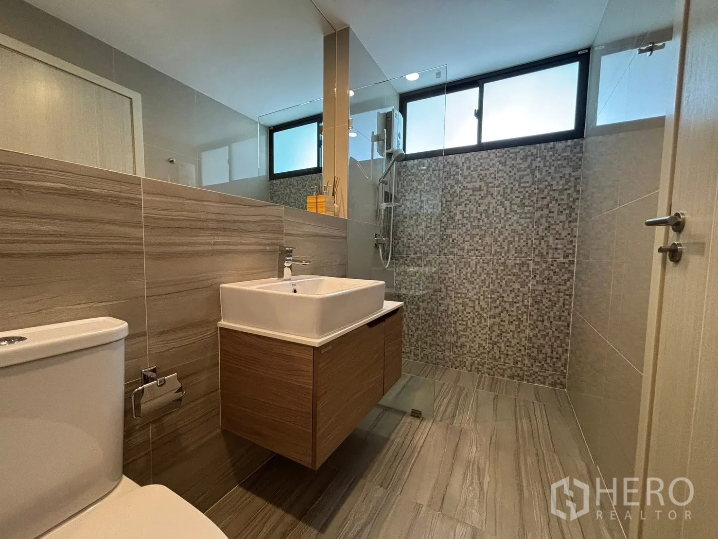 Townhouse for rent in Saphan Sung, Bangkok - Contemporary bathroom with floating vanity, toilet, and a walk-in shower with mosaic tiles.