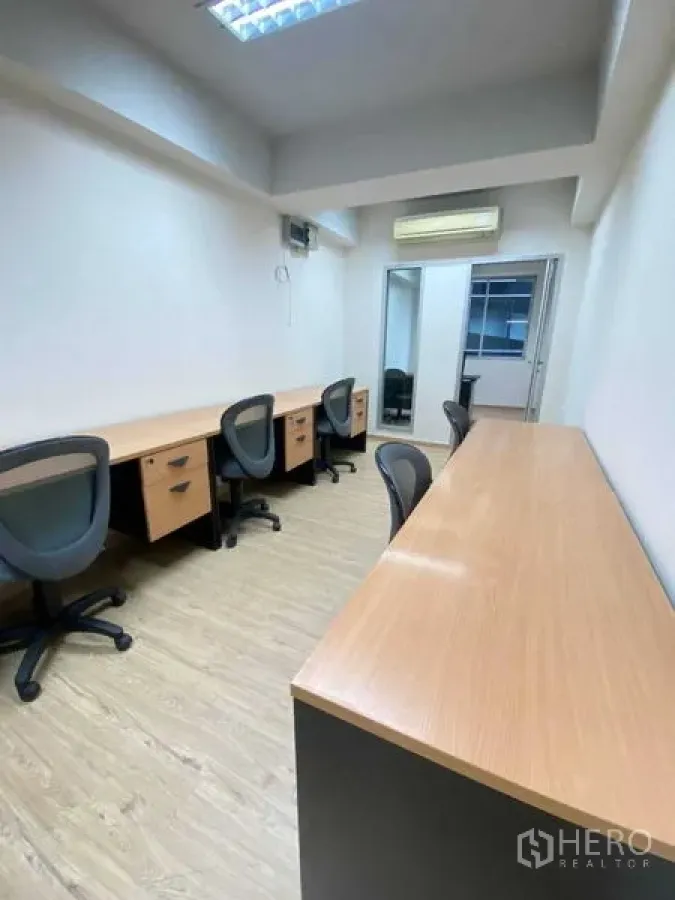 办公空间 出租在Khlong Toei, Bangkok - 长形办公区，多个内置工位、办公椅、壁挂空调与明亮荧光灯。