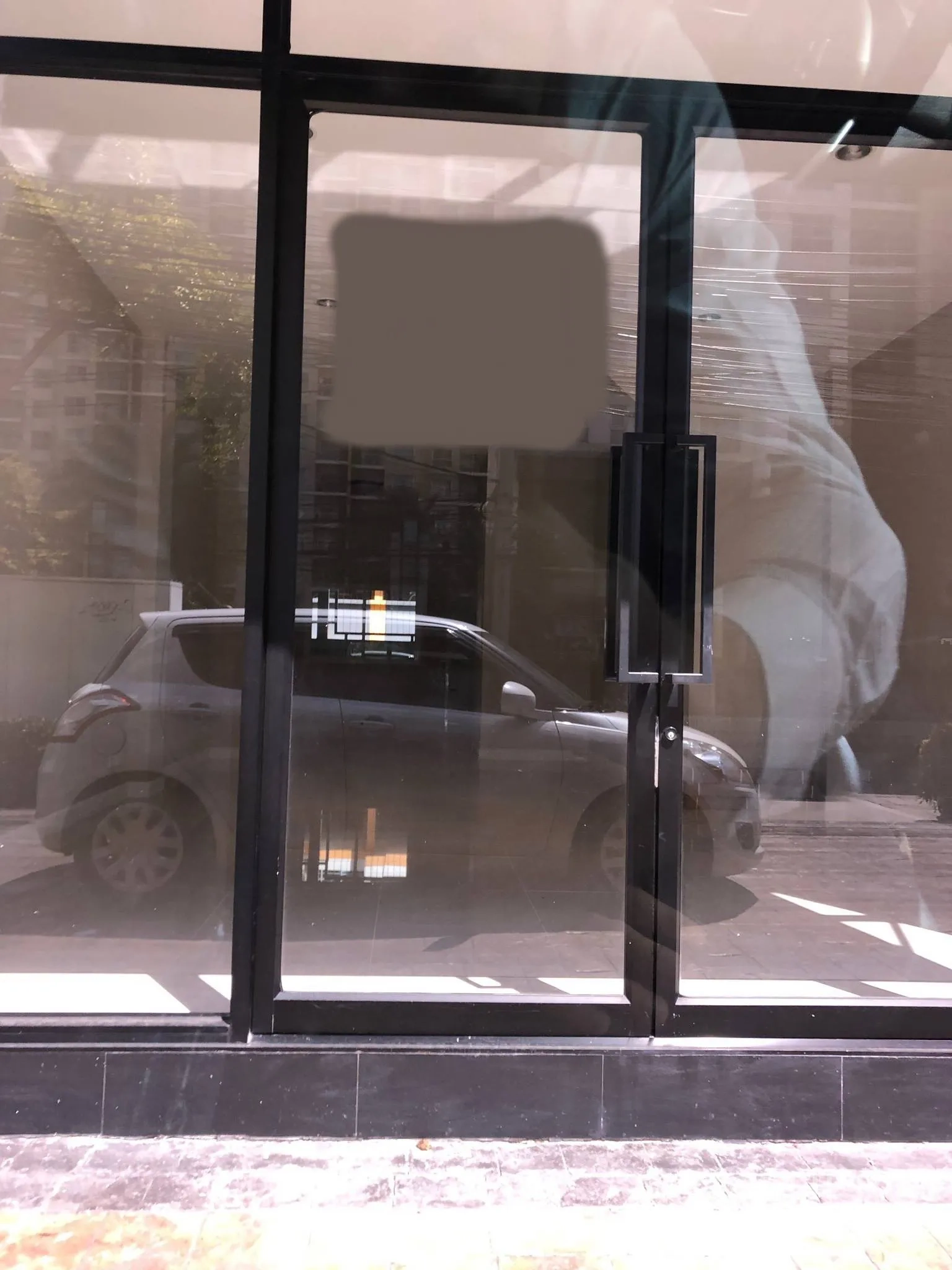 พื้นที่ขายปลีก ให้เช่าในPhra Khanong, Bangkok - หน้าร้านระดับถนน ประตูบานกระจกกรอบดำ กระจกเต็มสูง เห็นภายในโล่งพร้อมเงารถด้านนอก