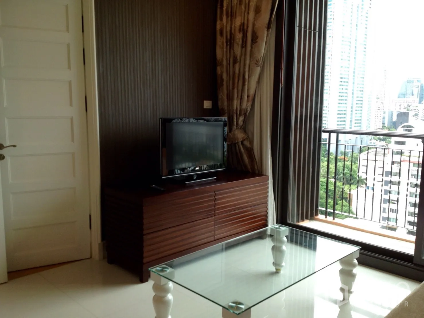 公寓 出租在Khlong Toei, Bangkok - 客厅连接阳台观景，推拉门旁配电视柜。