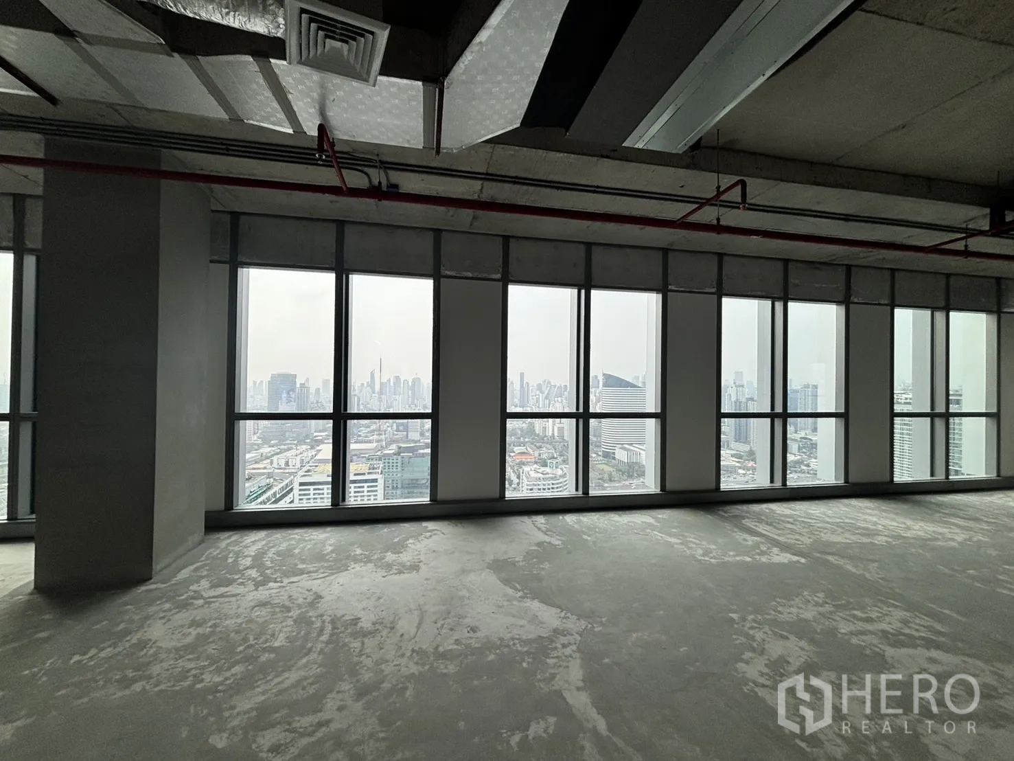 Office Space for rent in Huai Khwang, Bangkok - Bangkok skyline seen through tall floor-to-ceiling office windows.