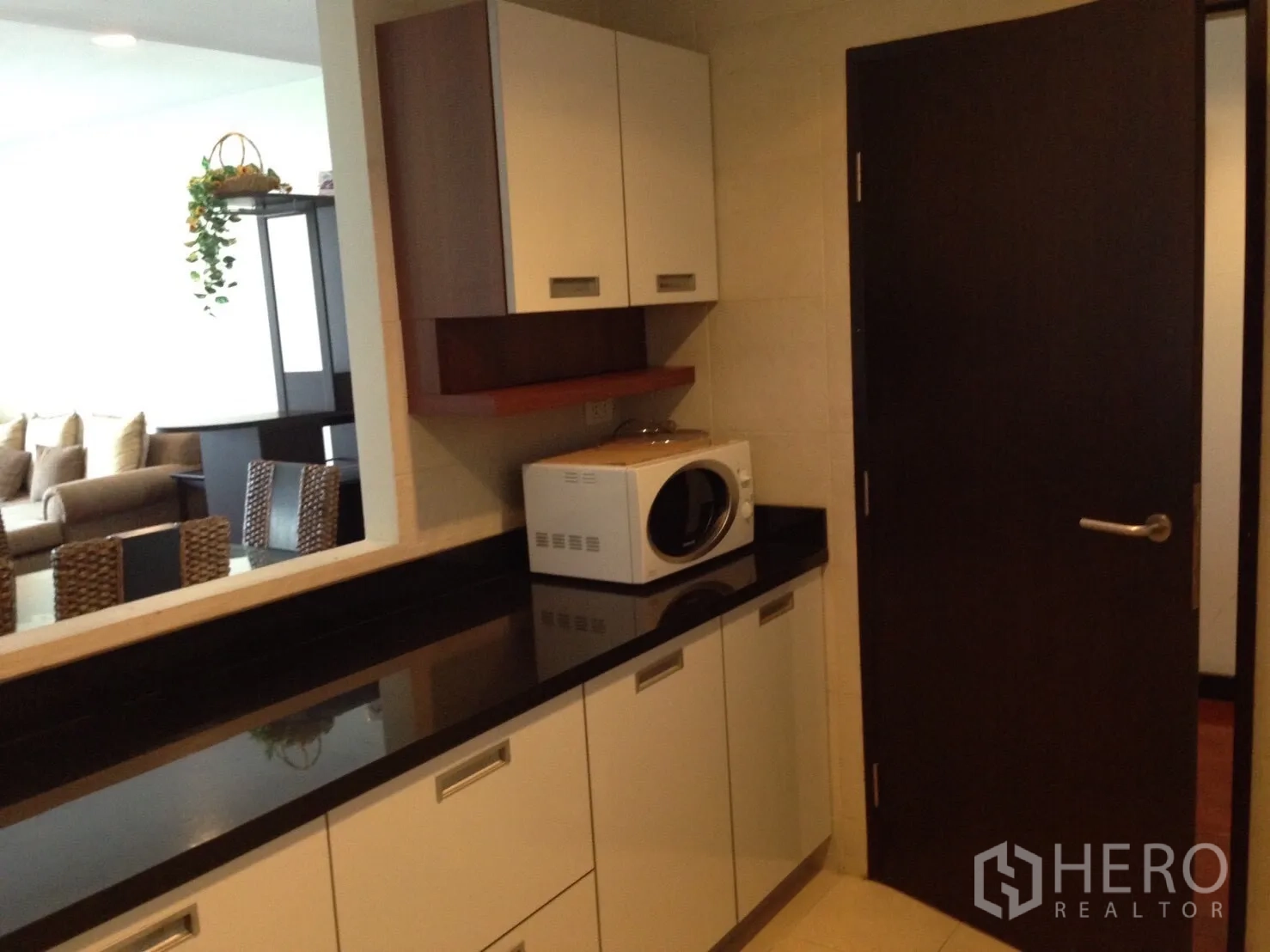 คอนโด ให้เช่าในKhlong Toei, Bangkok - แพนทรีตู้สีขาว เคาน์เตอร์หินสีดำ มีช่องเสิร์ฟเชื่อมห้องนั่งเล่น