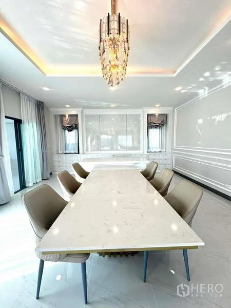 Detached House for rent in Bang Phli, Samut Prakan - Formal dining space with long marble table, eight chairs and chandelier lighting