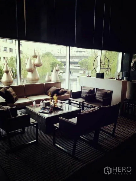 公寓 出租在Sathon, Bangkok - 沙吞公寓住户休息区，现代沙发与落地窗。