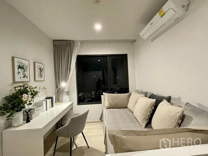 Condominium for rent in Pathum Wan, Bangkok - Second bedroom or study with daybed, long work desk and window to city skyline.