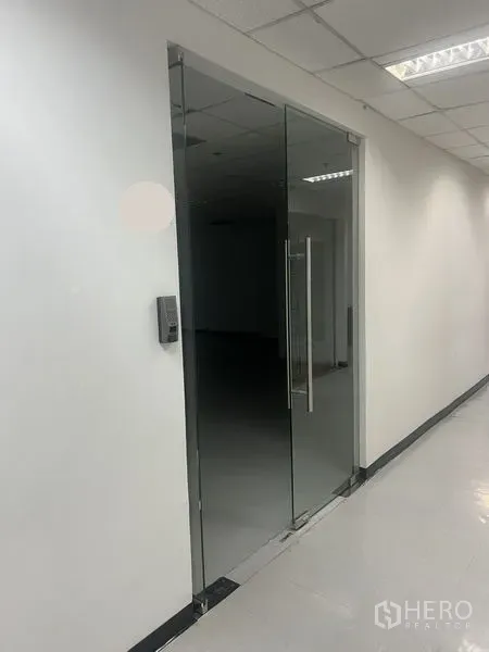 办公空间 出租在Watthana, Bangkok - 带门禁的玻璃门入口，明亮办公室与瓷砖地面。