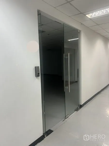 办公空间 出租在Watthana, Bangkok - 带门禁的玻璃门入口，明亮办公室与瓷砖地面。