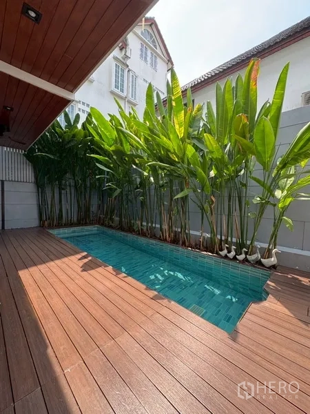 Semi-detached House for rent in Watthana, Bangkok - Private pool beside tall greenery and a warm wood deck.