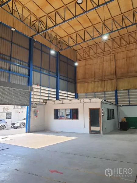 工厂 出租在Phra Pradaeng, Samut Prakan - 厂房空间带装卸卷闸门与内置办公室，高屋顶结构一览无余。