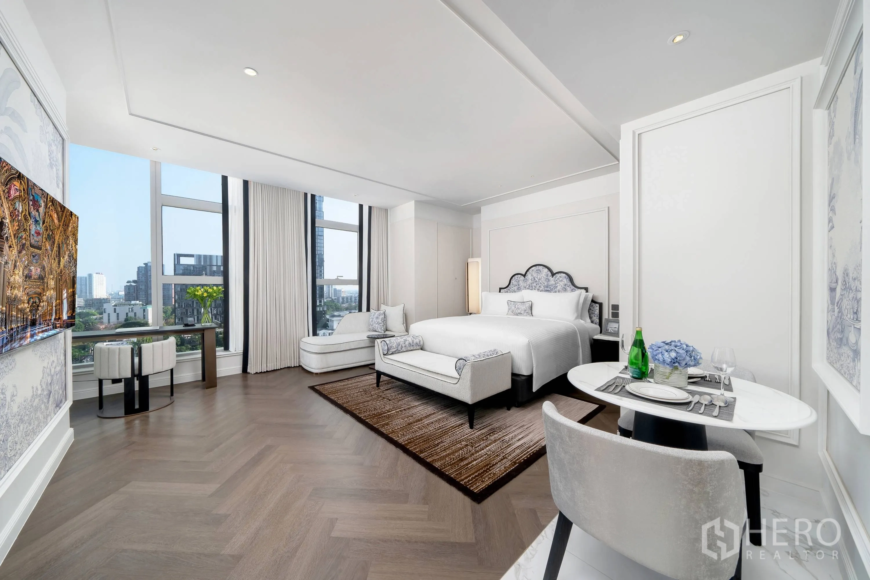 Condominium for rent in Khlong Toei, Bangkok - Bright open-plan bedroom with lounge chaise, dining nook, and expansive windows.