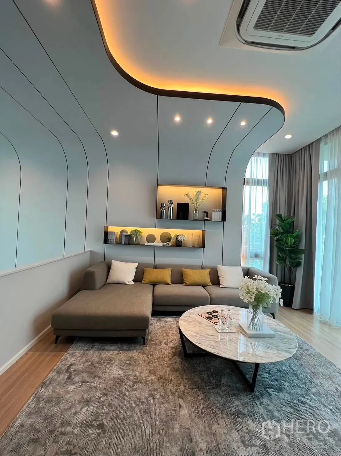 Townhouse for rent in Saphan Sung, Bangkok - Another living area with cove-lit ceiling, sectional sofa, and large windows.