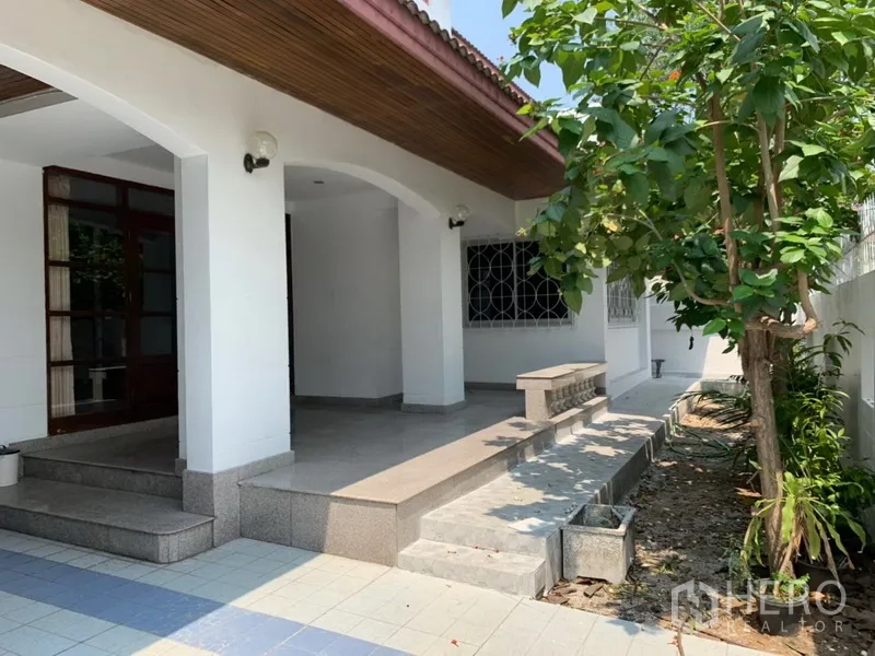 Detached House for rent in Khlong Toei, Bangkok - Covered front porch with arched columns, tiled steps and a small side garden.