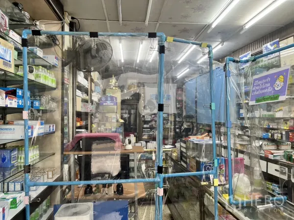 店屋 出售在Watthana, Bangkok - 收银台近景，透明隔断与排列整齐的货架