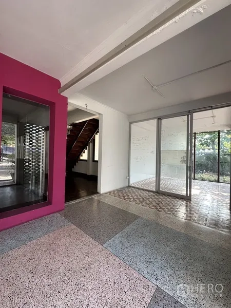 Detached House for rent in Phaya Thai, Bangkok - Entrance hall with terrazzo flooring, pink accent wall and glass sliding doors.