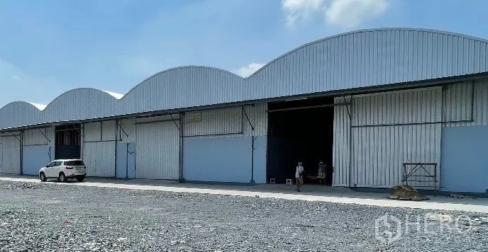 货栈 出租在Krathum Baen, Samut Sakhon - 仓库近景，带开启的卷闸装卸门及前部装卸区。