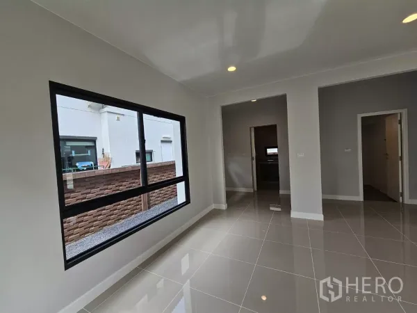 บ้าน ขายในLam Luk Ka, Pathum Thani - ห้องอเนกประสงค์ชั้นล่าง มีหน้าต่างบานกว้างและผนังโทนกลาง