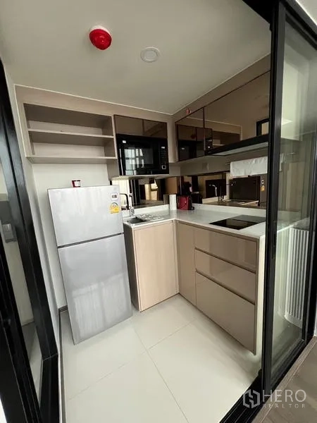 公寓 出租在Ratchathewi, Bangkok - 封闭式小厨房，内置柜体、电磁炉、微波炉与冰箱。