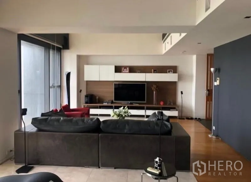 คอนโด ให้เช่าในSathon, Bangkok - ห้องนั่งเล่นหันหน้าไปยังผนังสื่อ พื้นไม้ และแสงธรรมชาติ