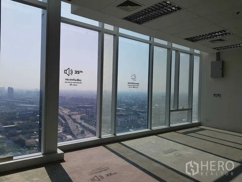Office Space for rent - Tall windows with skyline and highway views providing bright daylight across the office floor.