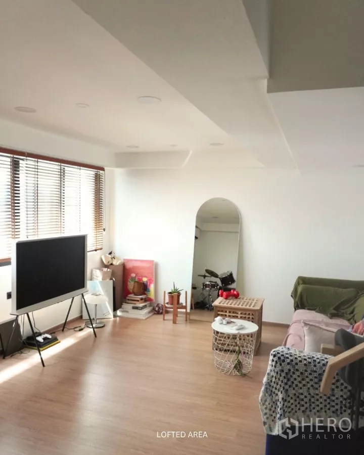 ทาวน์เฮาส์ ให้เช่าในSuan Luang, Bangkok - เลานจ์ชั้นลอฟท์เห็นกระจกเงาทรงโค้ง โซฟา และพื้นไม้