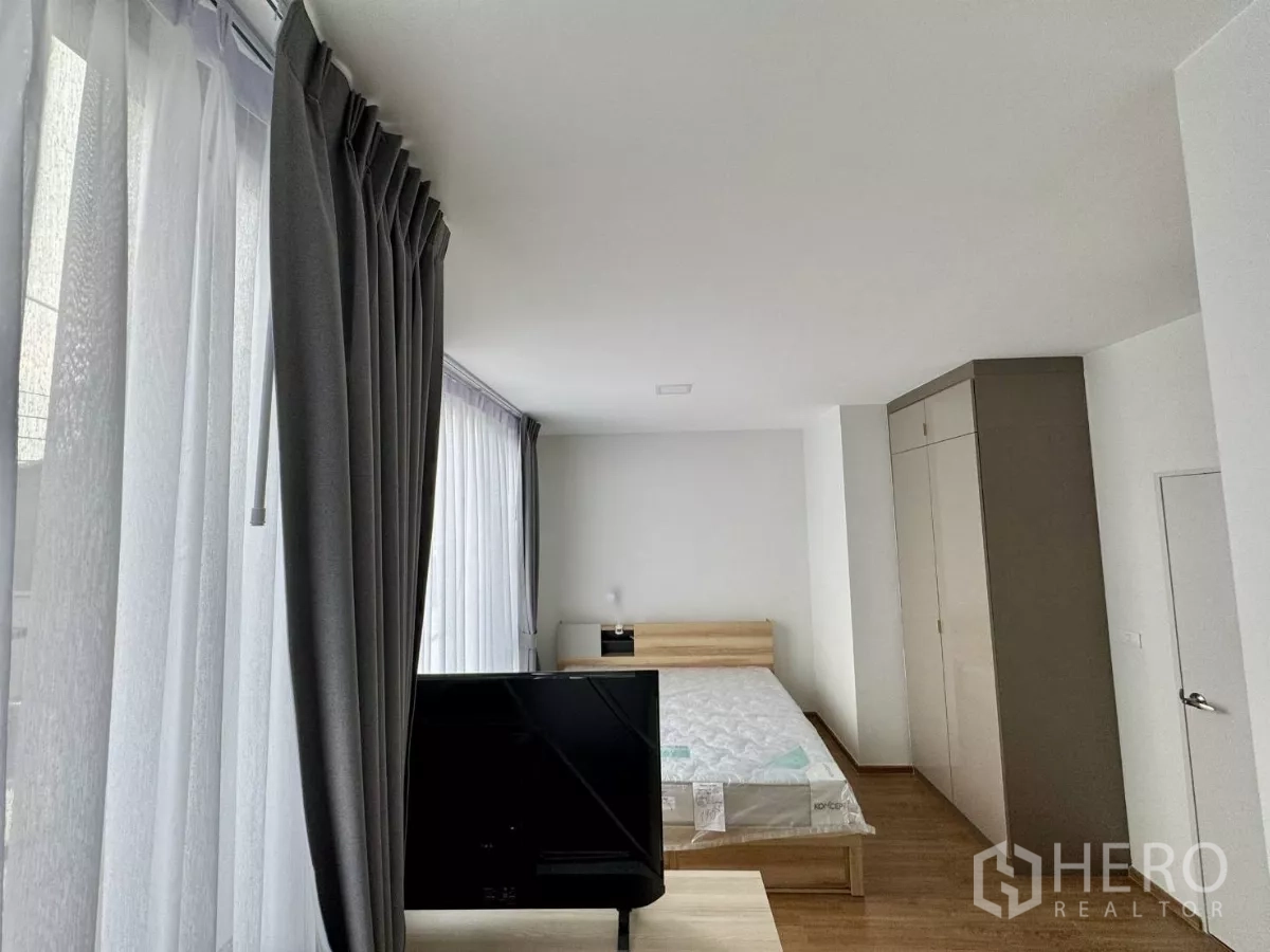 Townhouse for rent in Bang Phli, Samut Prakan - Master bedroom with floor-to-ceiling windows, bed and large wardrobes