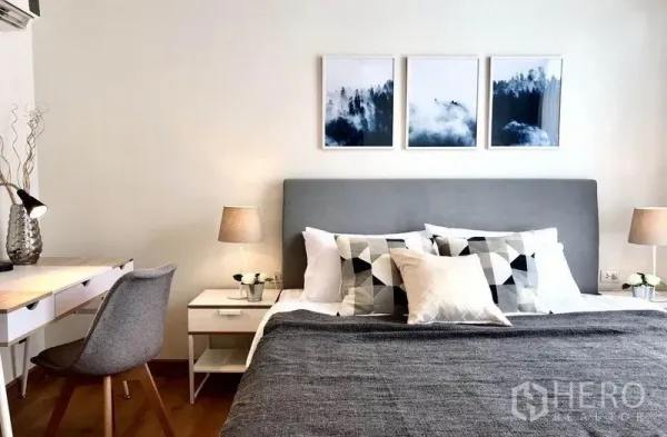 Condominium for rent in Watthana, Bangkok - Bright Thonglor condo bedroom with grey upholstered bed, bedside lamps, study desk, and modern wall art.
