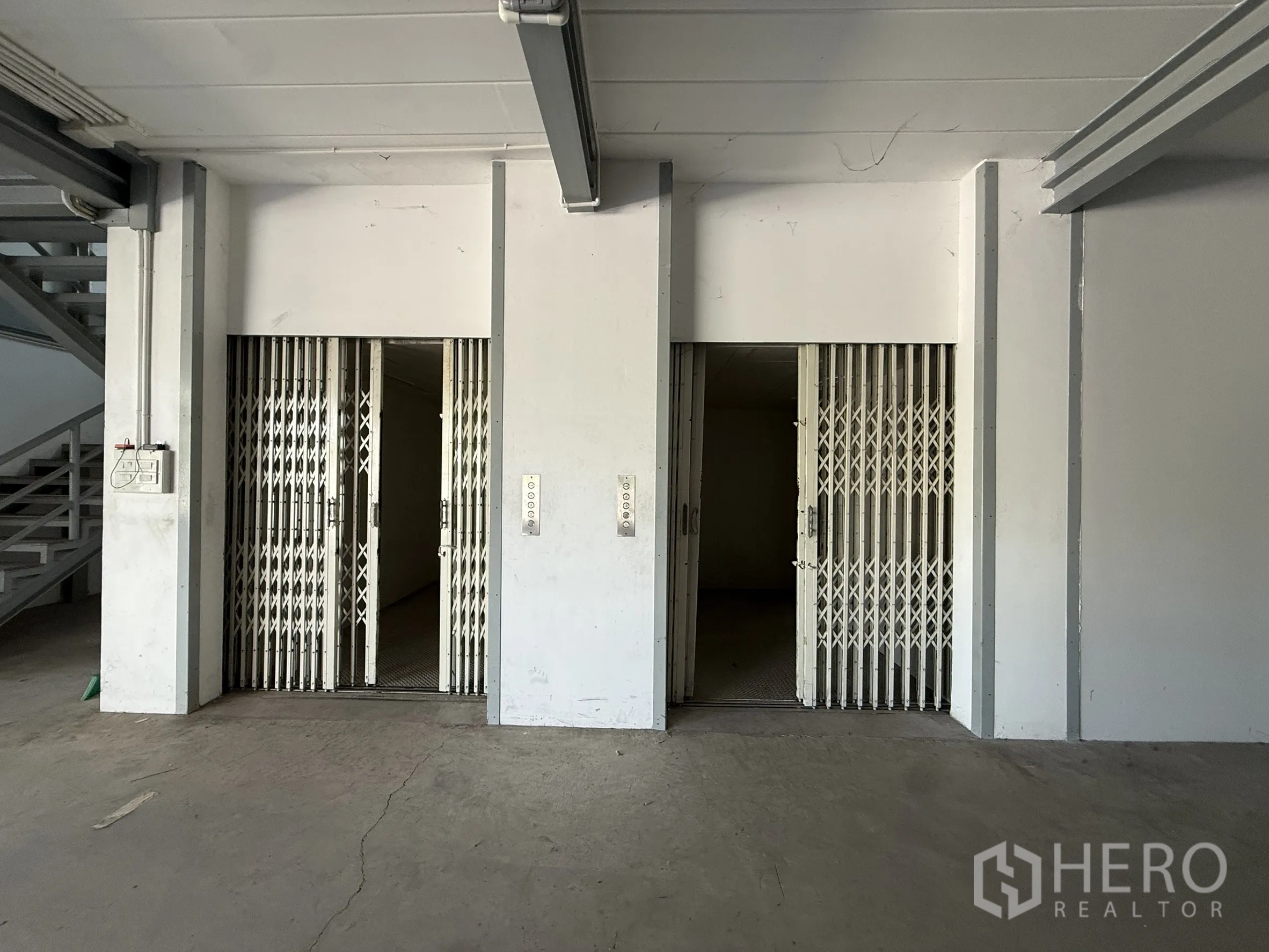 Warehouse for rent in Bueng Kum, Bangkok - Two freight elevators with folding gates beside the stairwell.