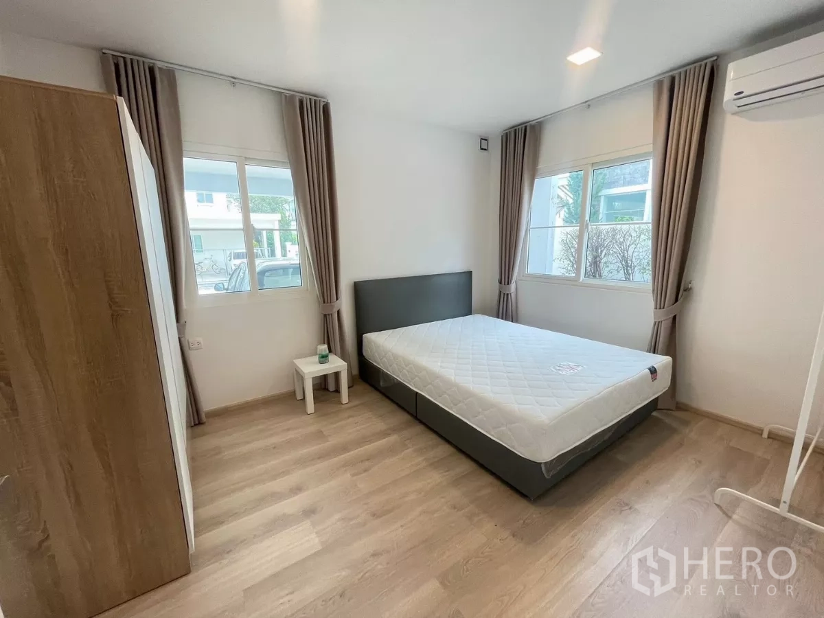 Detached House for rent or sale in Bang Phli, Samut Prakan - Ground-floor bedroom with double bed, wardrobe and corner windows.