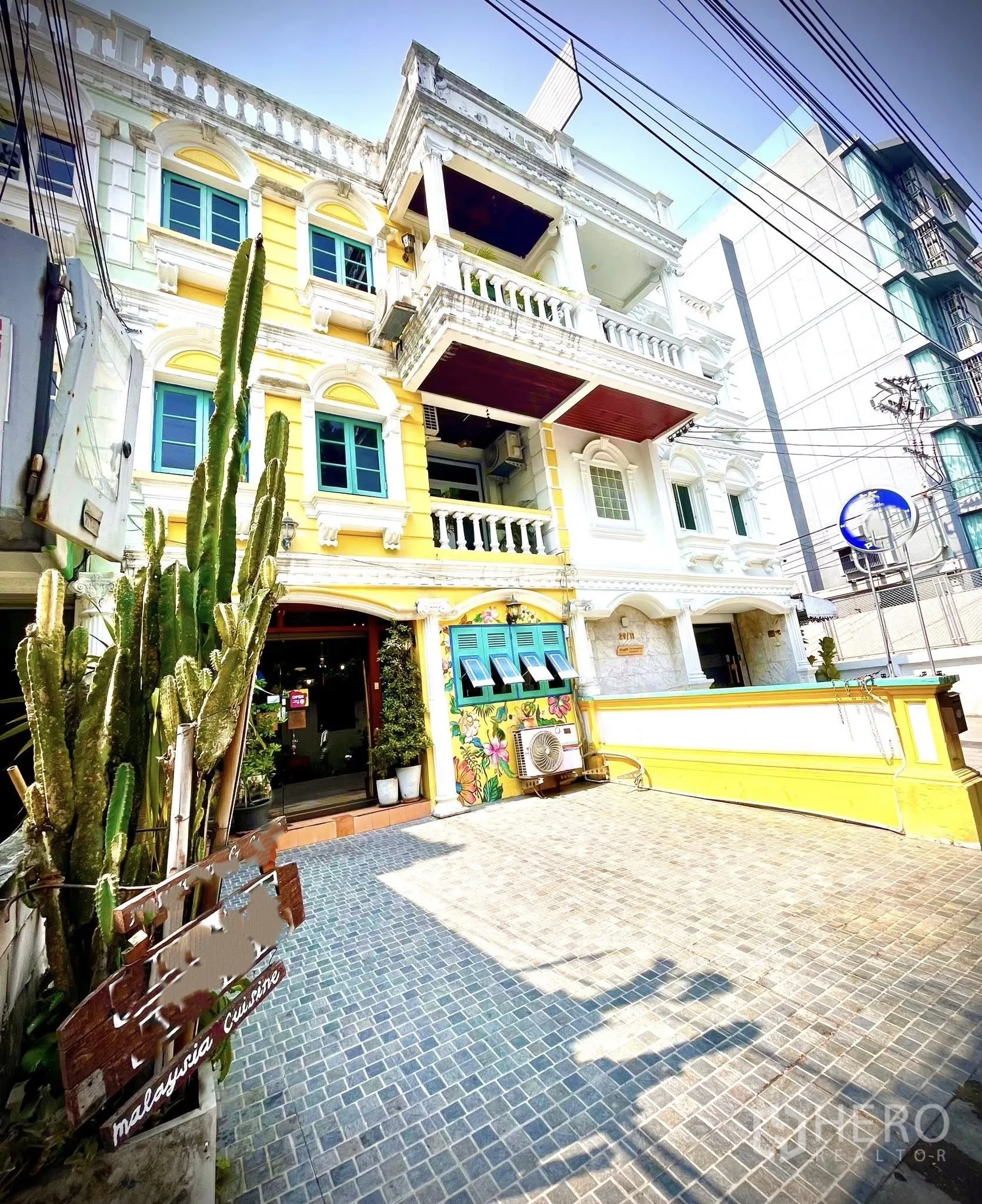 零售空间 for rent in Watthana, Bangkok - 黄色立面街屋外观，阳台、蓝色窗框与铺装前院。