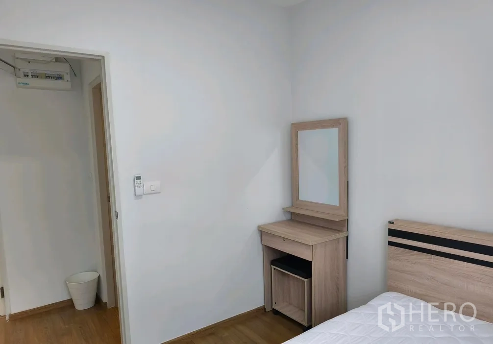 Townhouse for rent in Bang Phli, Samut Prakan - Bedroom corner with a wooden dressing table beside the bed.
