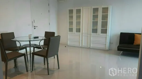 คอนโด ให้เช่าในPhaya Thai, Bangkok - พื้นที่รับประทานอาหารสว่าง โต๊ะกระจก เก้าอี้สี่ตัว ตู้โชว์สีขาว และโซฟาขนาดเล็ก