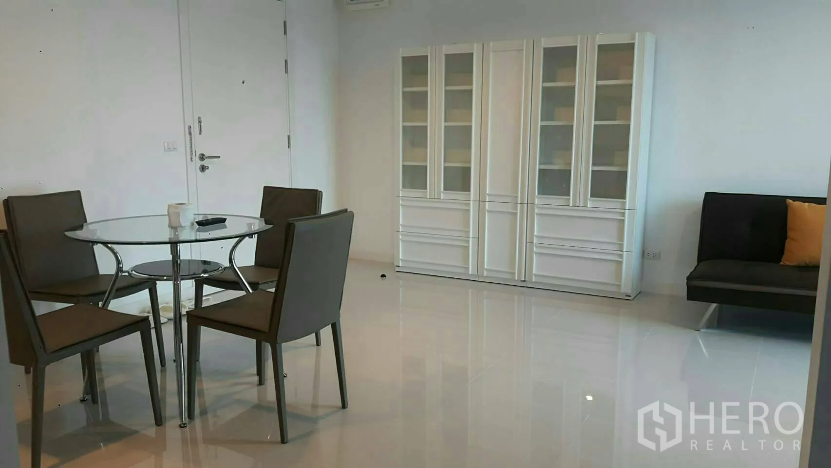 คอนโด ให้เช่าในPhaya Thai, Bangkok - พื้นที่รับประทานอาหารสว่าง โต๊ะกระจก เก้าอี้สี่ตัว ตู้โชว์สีขาว และโซฟาขนาดเล็ก