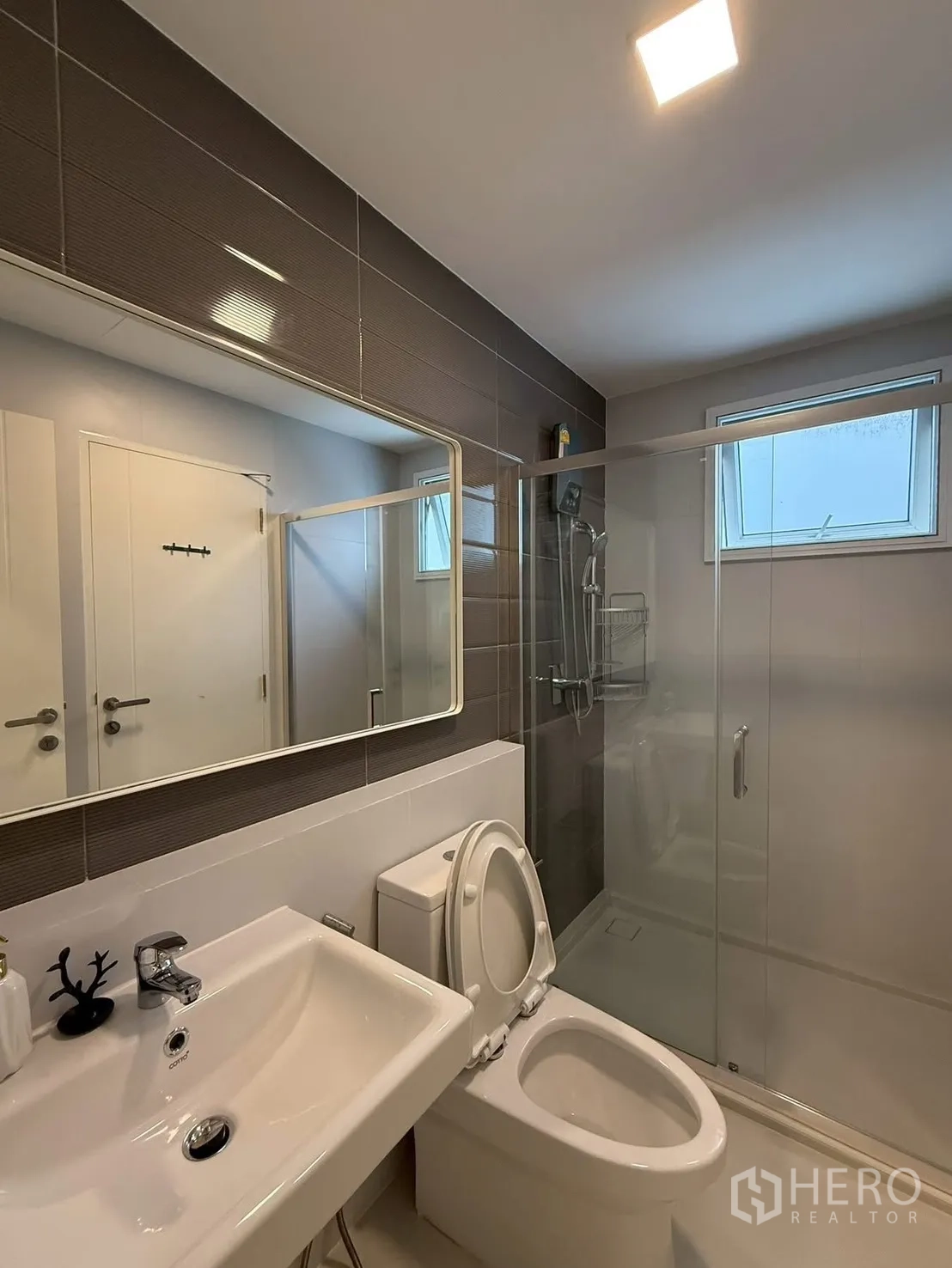 Detached House for rent in Bang Phli, Samut Prakan - Modern bathroom with brown accent tiles and sliding glass shower.