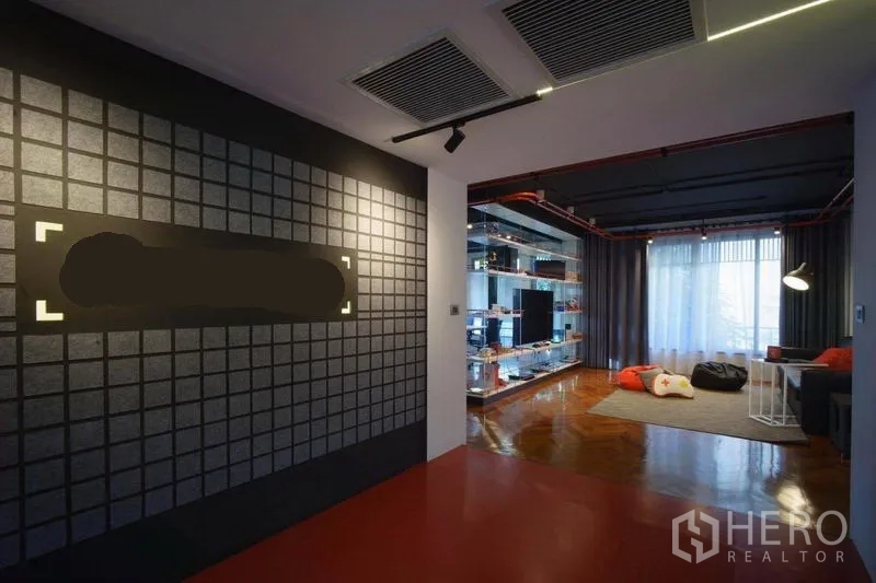Office Space for rent in Khlong Toei, Bangkok - Reception and lounge area with a grid accent wall, shelving and curtain-lined windows.