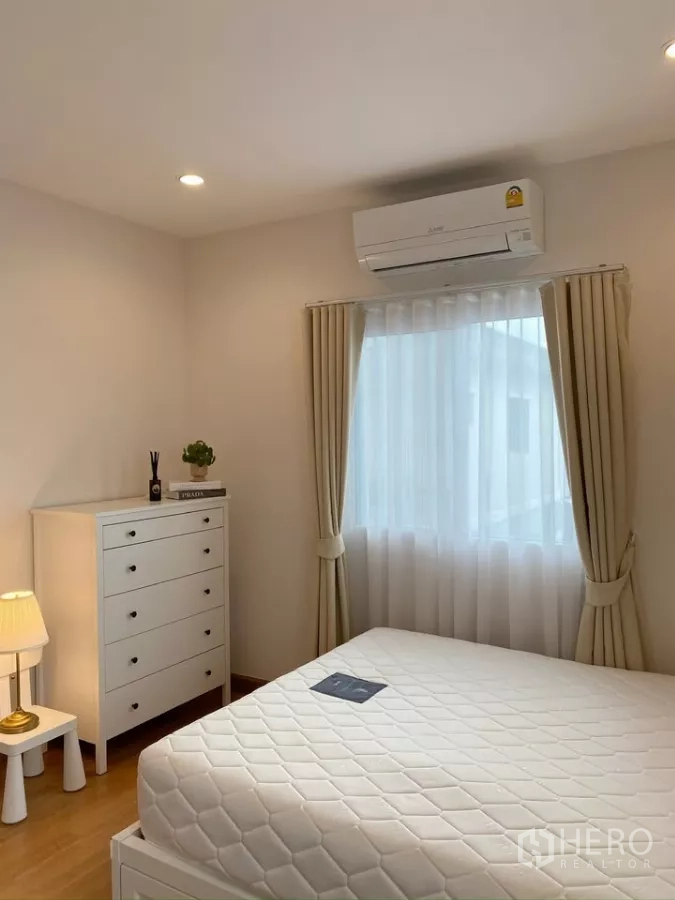 独立式住宅 出售在Sai Mai, Bangkok - 次卧明亮，五斗柜、空调与柔和窗帘。