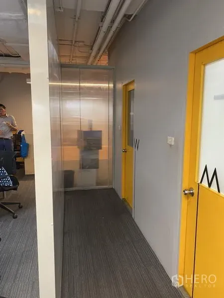 สำนักงาน ให้เช่าในKhlong Toei, Bangkok - โถงทางเดินพร้อมประตูล้อมสีเหลืองและผนังกระจก เชื่อมสู่พื้นที่ทำงาน