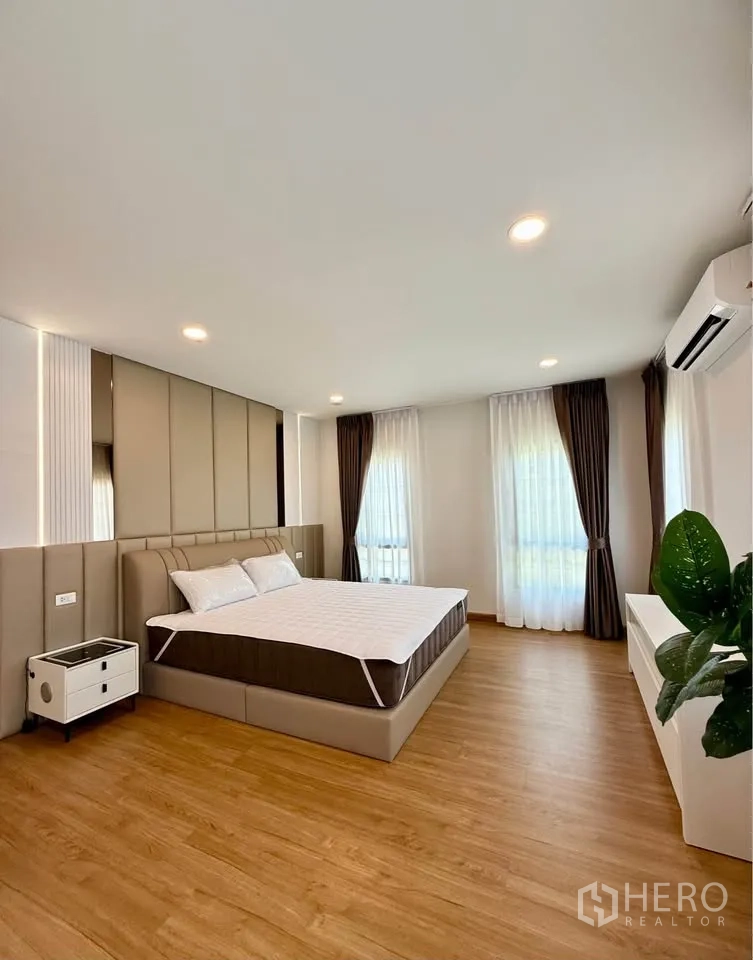 Detached House for rent in Bang Phli, Samut Prakan - Large master bedroom with big windows, wood floors, and air conditioning.